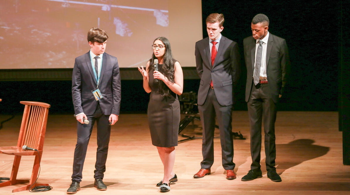 Student speaking on stage at a Model UN event