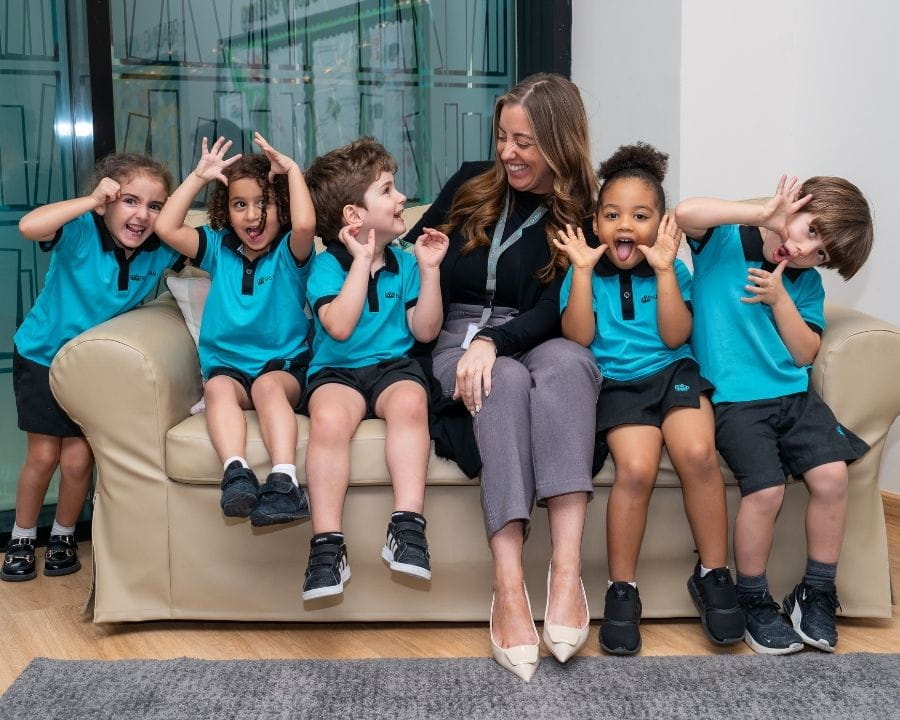 Deputy head of primary with students smiling 