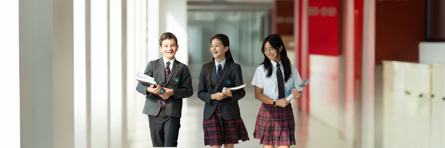 NAS Dubai students dressed in smart school uniforms walking through the corridors 