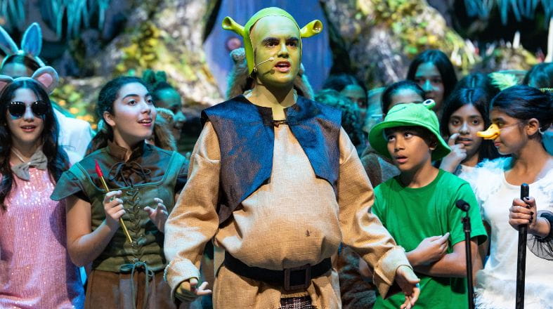 Students performing Shrek the Musical on stage at NAS Dubai