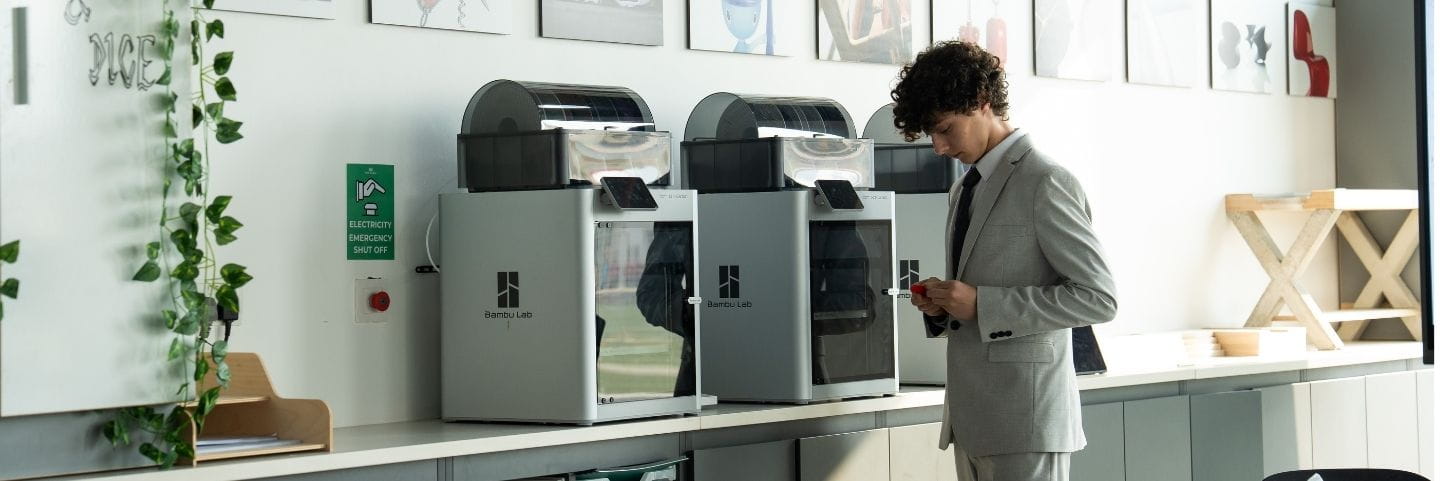 A modern DT lab featuring multiple state-of-the-art 3D printers arranged on a sleek counter in a bright, professional workspace.
