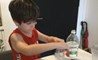 A primary student does a science experiment during virtual school