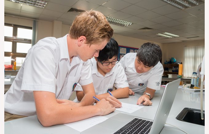 Two secondary boys learning with computer