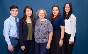 5 members of the admissions team posing side by side in front of a blue background