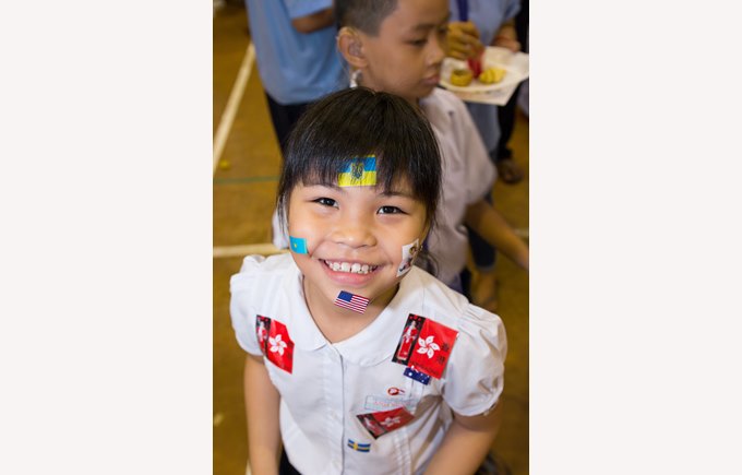 STudent from Community Service Partner with intl stickers all over her face