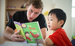 Boy reading with teacher