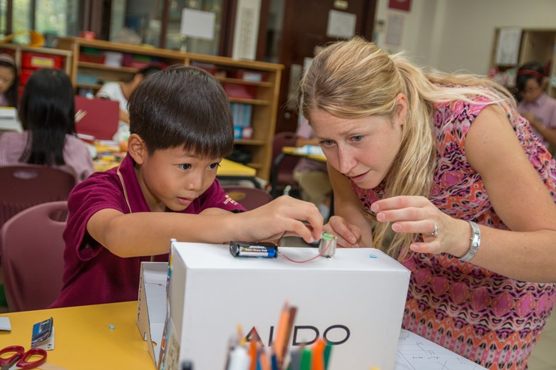 Image of teacher helping a Primary student during Science week