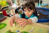 EYFS girl playing with toy girraffe