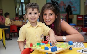 Boy and adult smiling with lego blocks