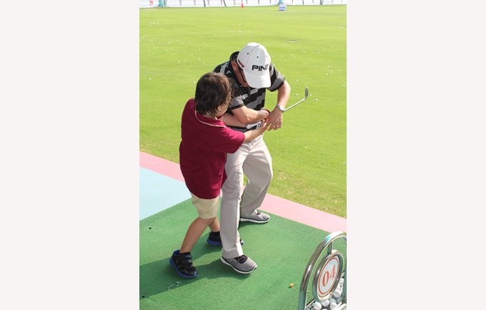 Student being taught how to play golf by instructor