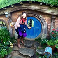 Women travelling New Zealand in front of hobbit house