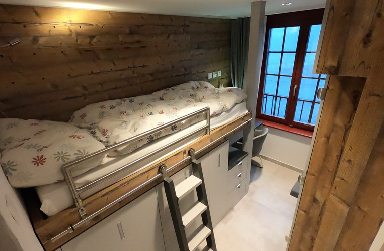 Boarding room with bed and ladder