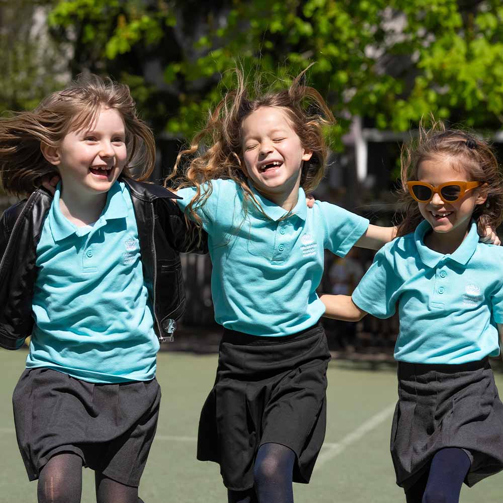 three happy girls on the school pitch