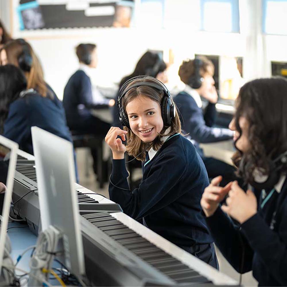 students in a music room with pianos